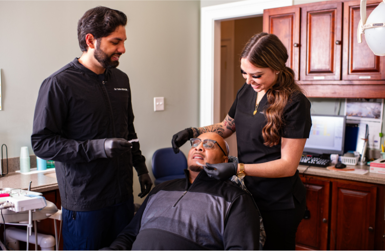 Dr. Iqbal and assistant working on a patient
